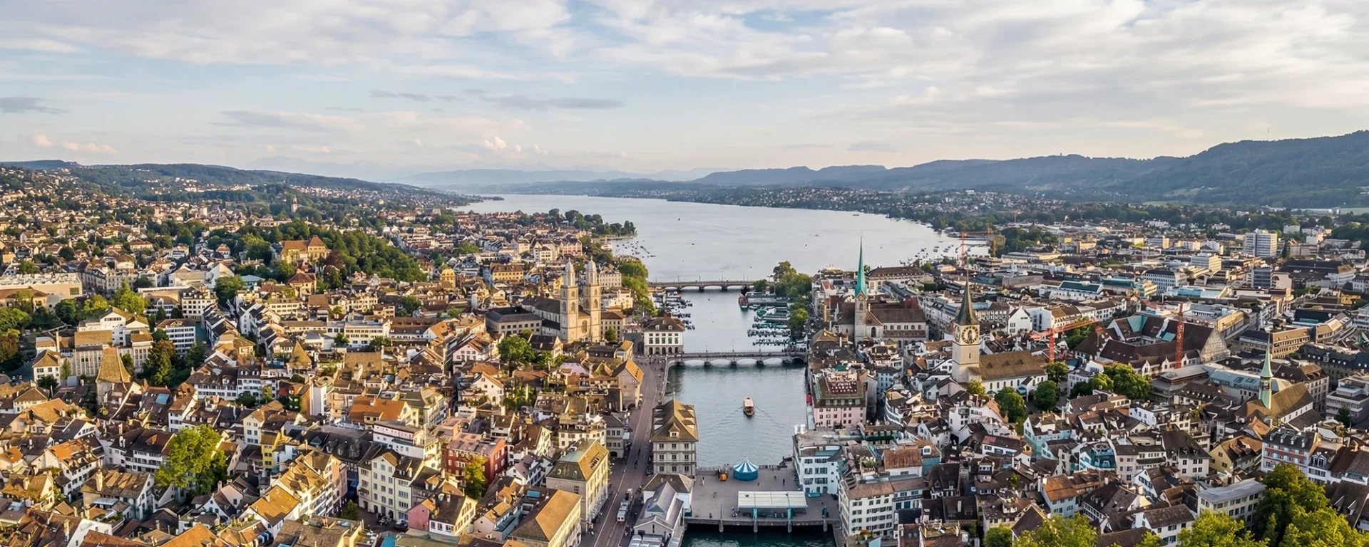 Luftaufnahme von Zürich mit Sehenswürdigkeiten und Zürichsee im Hintergrund, ideal zur Darstellung urbaner Schönheit und architektonischer Vielfalt.